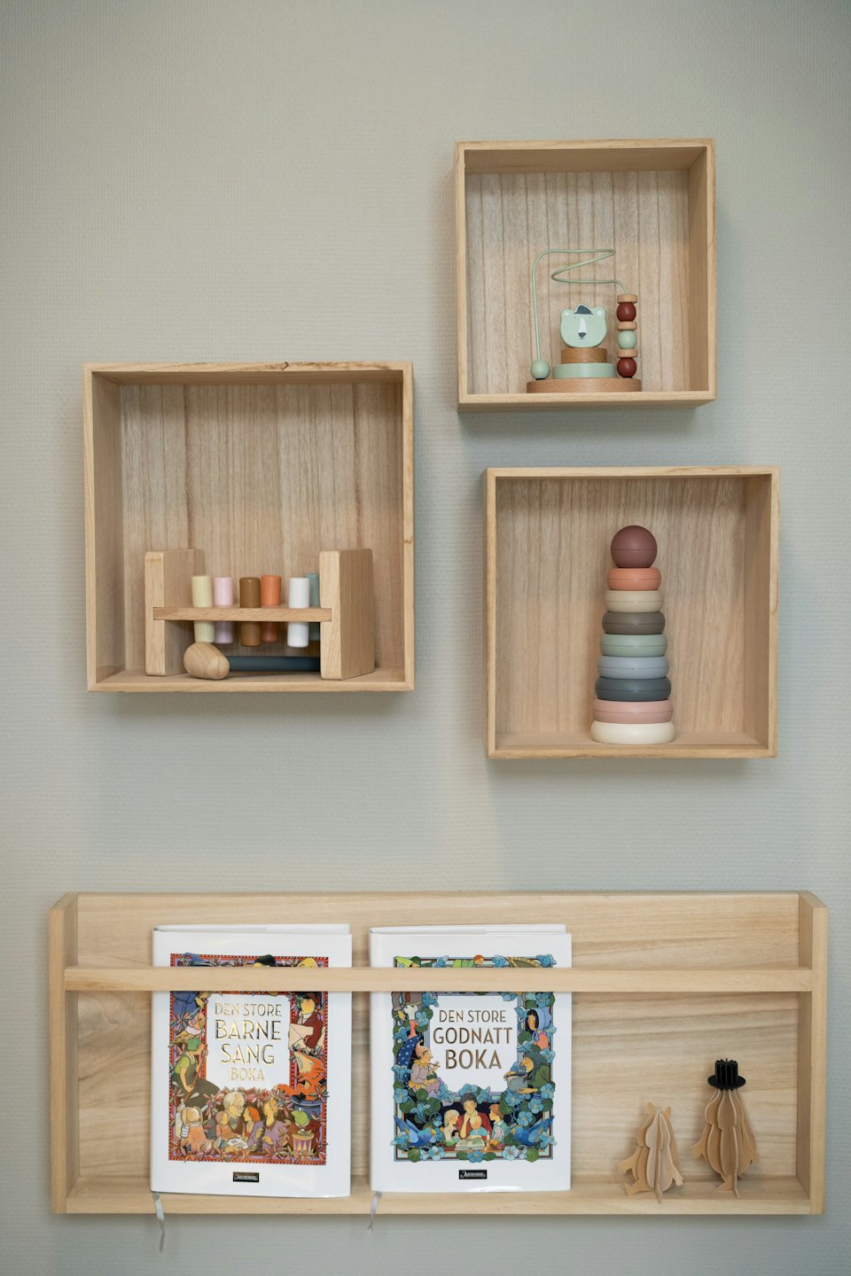 Wooden shelves on a wall display children's toys and books.